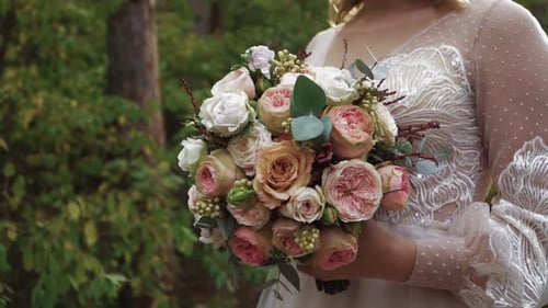 Elegant Bride Holds Floral Bouquet Outdoors