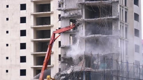Demolition Machine Dismantling Concrete Building in City
