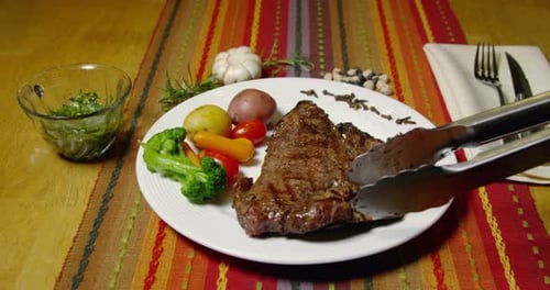 Steak Placed on Plate Next to Vegetables