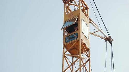 Ouvrier dans le poste de pilotage d'une grue