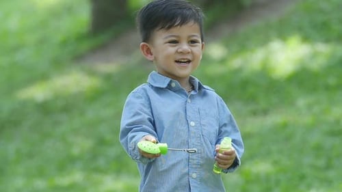 Boy Making Bubbles in a Green Park