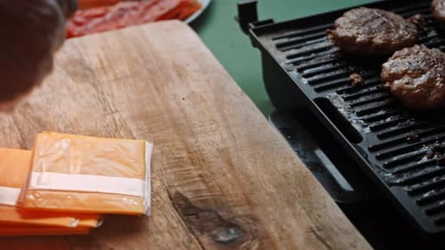 Adding Cheese to Freshly Cooked Burger Patties