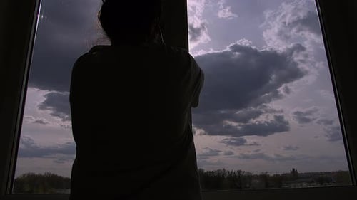 Woman Opens a Window Beautiful Clouds Float Across the Sky in the Evening
