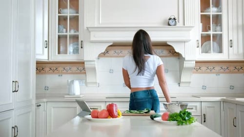 Woman Dancing and Juggling Tomato in Kitchen
