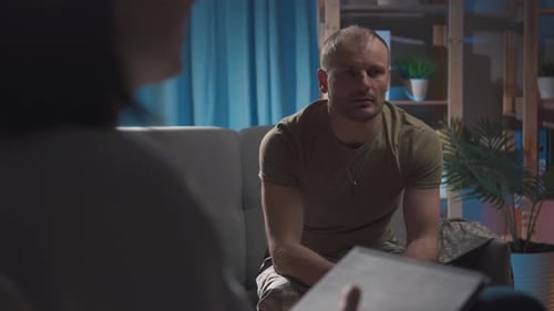 Man Talking with Therapist on Couch Indoors