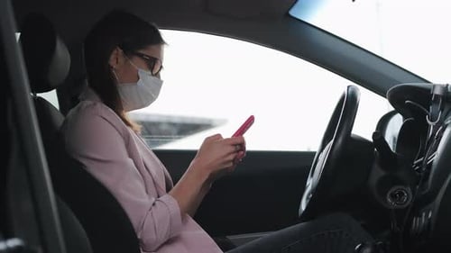 Woman Using Smartphone in the Driver's Seat