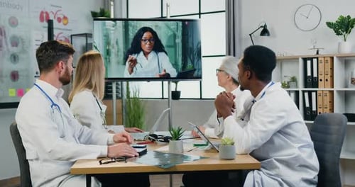 Doctors Collaborate via Video Conference at Workplace