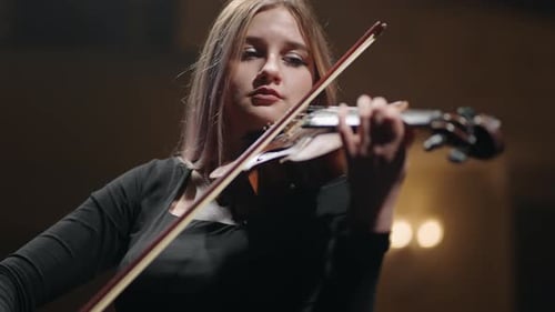 Pretty Woman is Playing Violin on Scene in Music Hall Portrait of Female Musician on Scene of Music