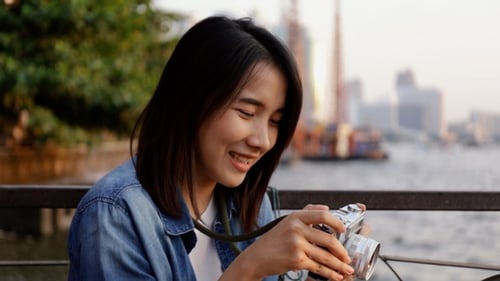 Young Woman Takes Photo With Camera by River