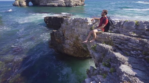 Young man sitting on the cliff.