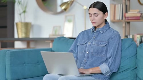 Woman Massaging Wrist While Using Laptop