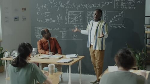 African American Student Explaining Formulas on Blackboard