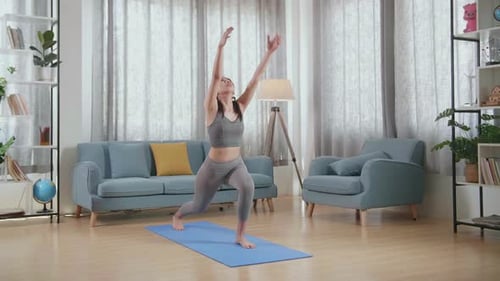 Young Woman Performing Yoga Exercises at Home
