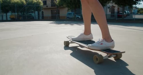 Teenager Ride on Skate Longboard Closeup Legs on Sport Field in City