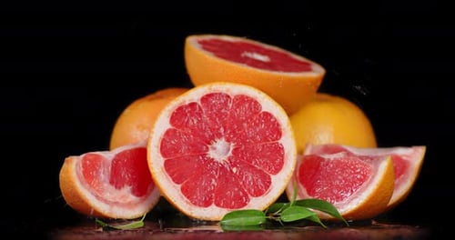 Fresh Grapefruit Slices with Water on Black Background