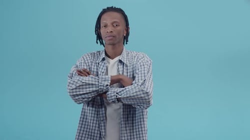 Young adult crosses arms looking at camera