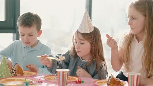Group of Children Eating at Birthday Party in Funny Decorations