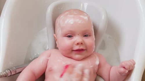 Happy Infant Getting a Bath with Washcloth and Soap