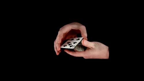 L'astuce de magicien avec des cartes : changer la carte, sur fond noir, gros plan, vue latérale