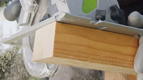 Power Saw Cutting Wood Plank with Sawdust