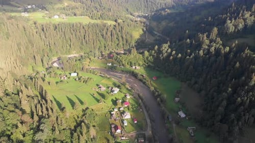 Aerial View of the Carpathian Mountain Valley with Green Meadows and Trees