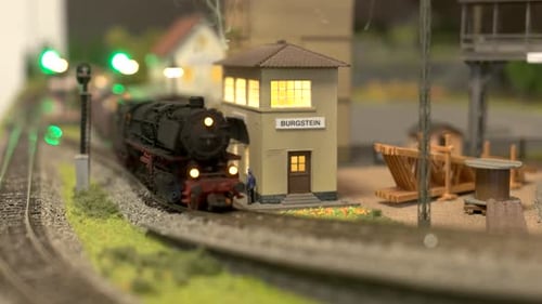 Modelo de trem se movendo ao longo da estação ferroviária.