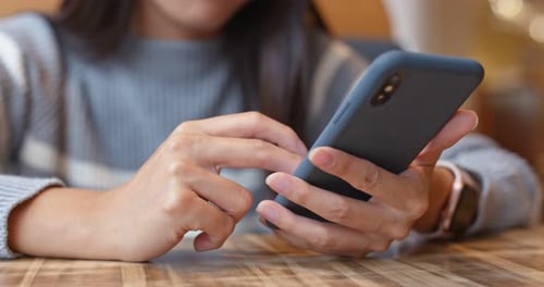 Woman use of mobile phone inside restaurant