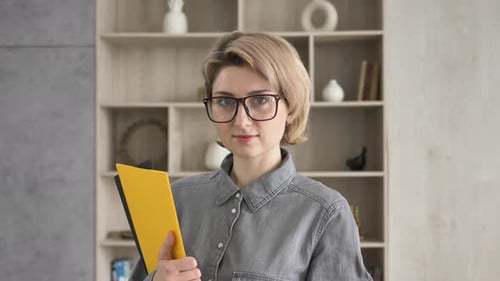 Smiling Woman with Glasses Holding Clipboard