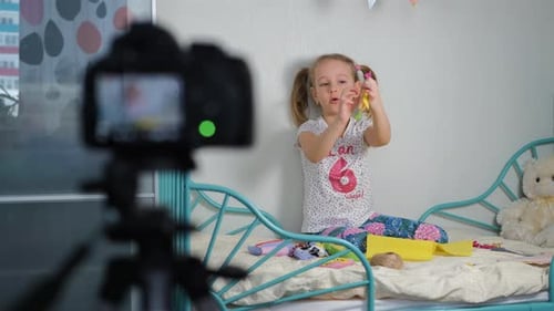 Niña graba un vlog sobre juguetes de fabricación propia
