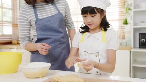 Girl and Woman Baking Together in Bright Kitchen