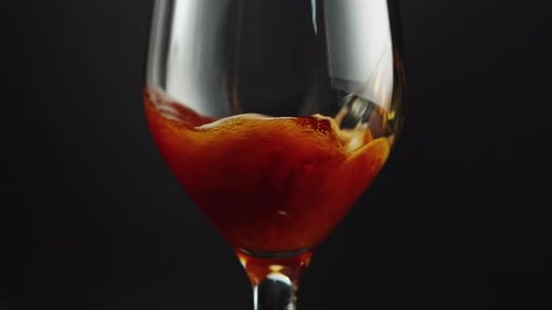 Brown Liquid Pouring into Wine Glass Close Up