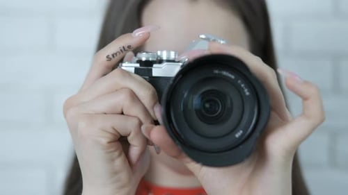 A female photographer asks for a smile.