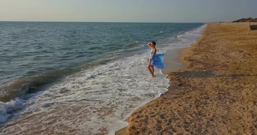 girl on the beach in a dress near the sea