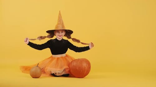 Little Blonde Girl in Witch Costume on Halloween at Orange Studio Background