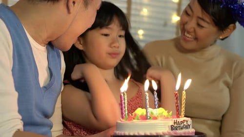 Family Celebrates Birthday with Cake and Candles