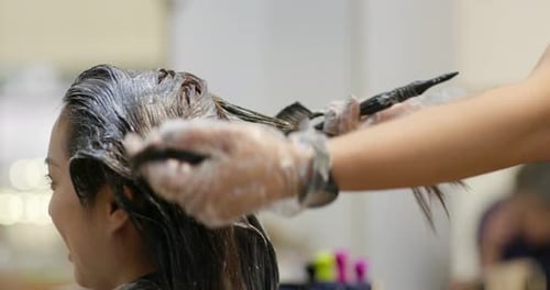 Hair Stylist Applying Dye to Woman's Hair