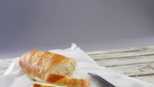 Sliced Baguette on a Wooden Surface with Knife