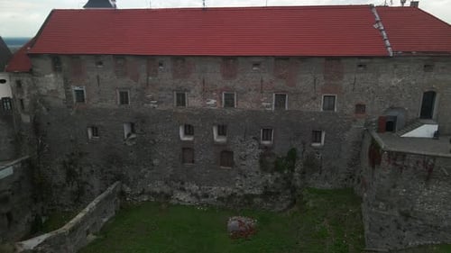 Drone Flies Over Medieval Castle on Mountain in Small European City at Cloudy Autumn Day