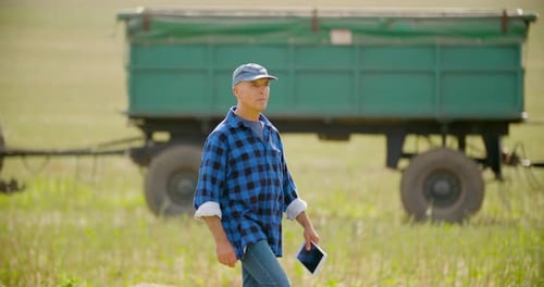 Farmer with Tablet Walking through Harvested Field