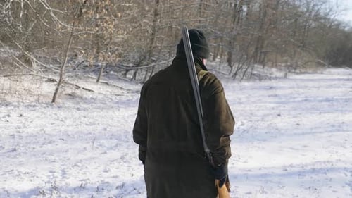 Hunter Walking in the Snowy Winter Forest. Winter Hobby, Sun, Hunting Concept.