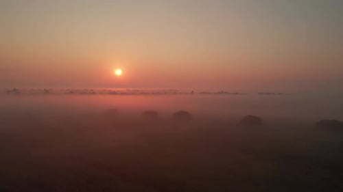 Misty Sunrise Over Foggy Rural Landscape