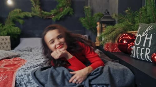 Woman Relaxing on Decorated Bed During Christmas
