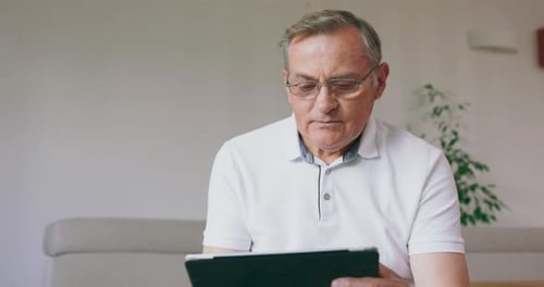 Mature Adult Man Using Tablet Indoors