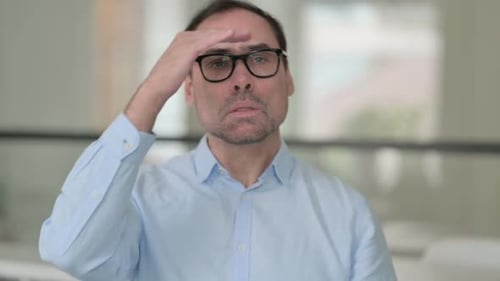 Man Gestures Towards Camera in Blue Shirt