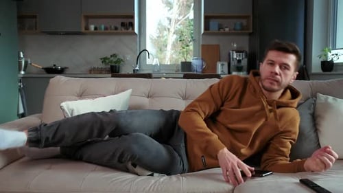 Man Jumping on Sofa and Watch TV