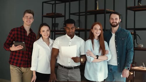 Portrait of Successful Smiling Multi-ethnic Business Team Standing in Modern Office .