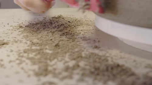 Hand Sweeping Up Debris After Art Project