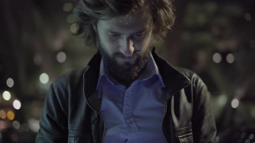 Bearded Man Uses Smartphone at Night