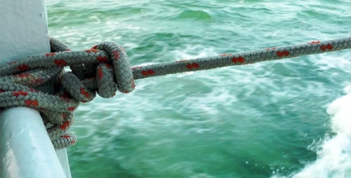 Rope Tied On Boat Rail Near Waves