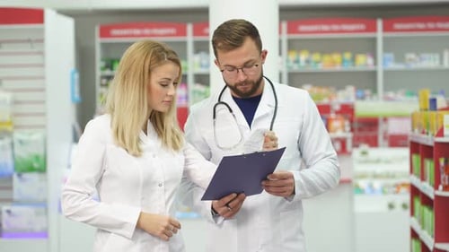 Dos farmacéuticos hablan sobre el uso de medicamentos en la farmacia.